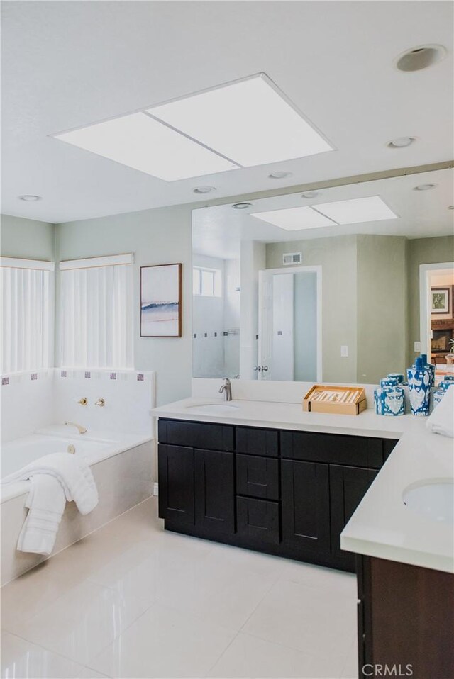 bathroom with vanity, a tub to relax in, and tile patterned floors