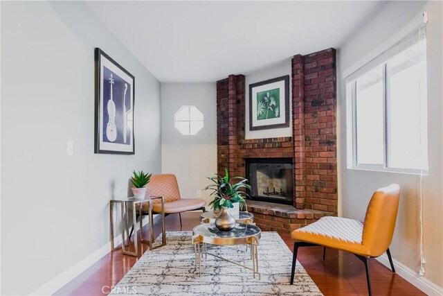 living area with a fireplace and wood-type flooring