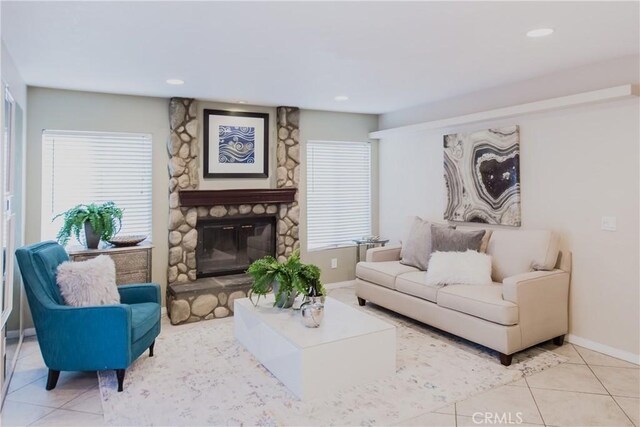 living room featuring a wealth of natural light, a fireplace, and light tile patterned flooring