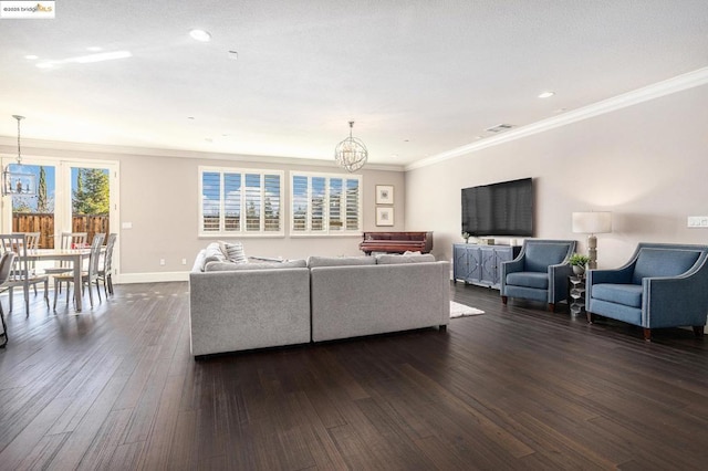 living room featuring ornamental molding, a notable chandelier, and dark hardwood / wood-style flooring