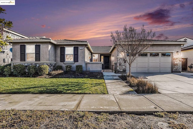 view of front of property with a yard and a garage