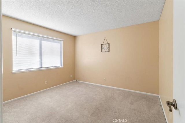 carpeted spare room featuring a textured ceiling