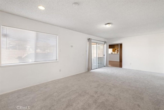 carpeted spare room featuring a textured ceiling