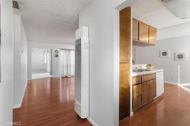 hallway featuring dark hardwood / wood-style flooring, sink, and a textured ceiling