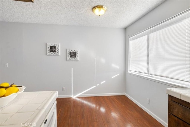 laundry room with hardwood / wood-style flooring and a textured ceiling