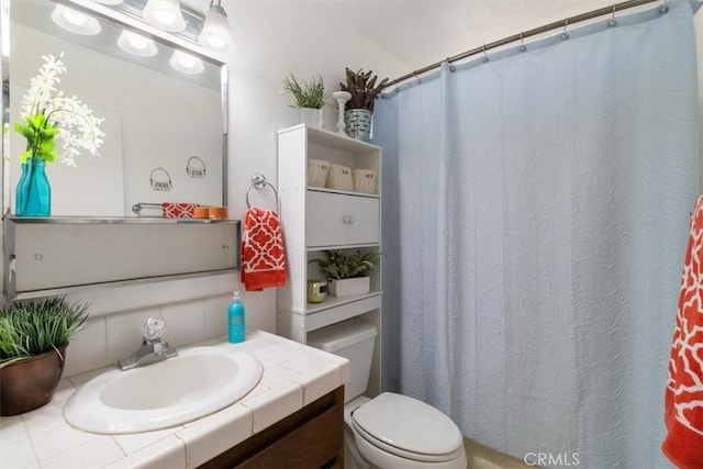 bathroom featuring vanity, backsplash, toilet, and a shower with shower curtain