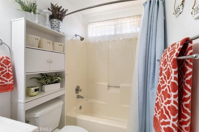 bathroom featuring shower / bathtub combination with curtain and toilet