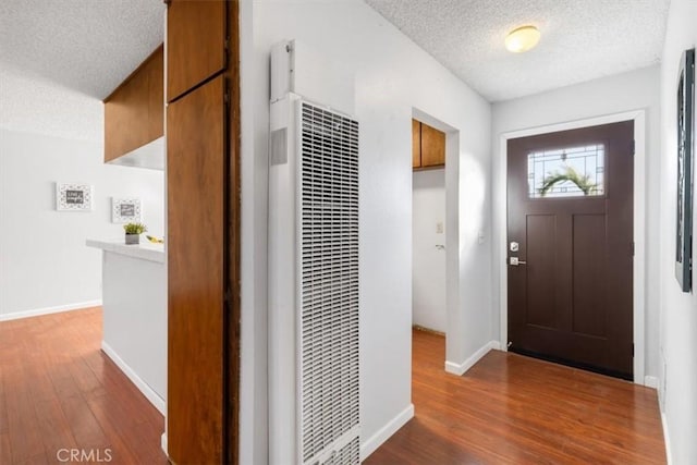 foyer entrance with dark hardwood / wood-style flooring and a textured ceiling