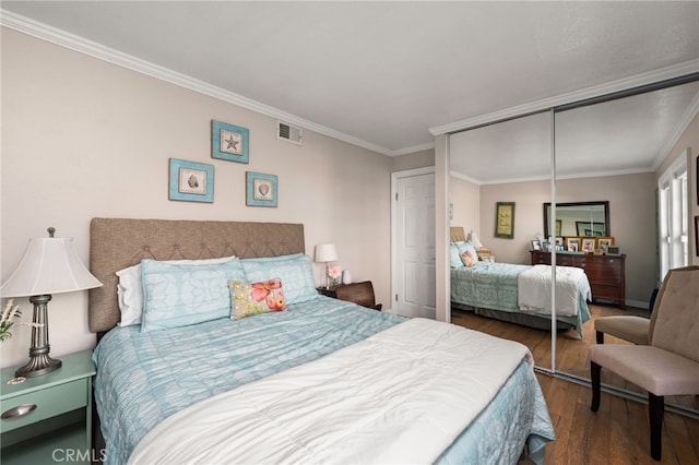 bedroom featuring crown molding, wood-type flooring, and a closet