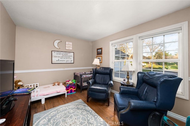 living area featuring a healthy amount of sunlight and dark hardwood / wood-style flooring