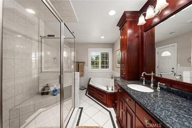 bathroom with plus walk in shower, tile walls, tile patterned floors, and vanity