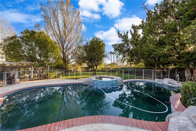 view of swimming pool with an in ground hot tub