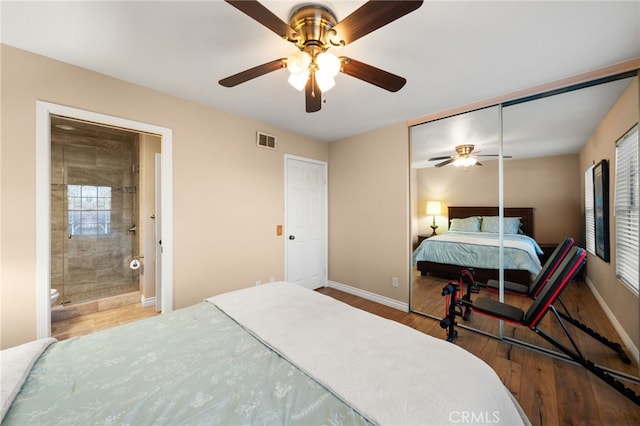 bedroom featuring hardwood / wood-style flooring, ensuite bathroom, ceiling fan, and a closet