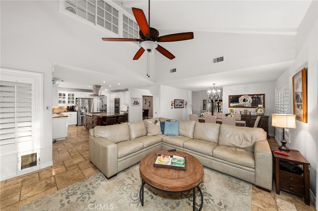 living room featuring ceiling fan with notable chandelier and high vaulted ceiling