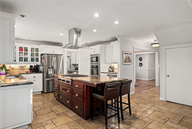 kitchen with a breakfast bar area, white cabinetry, stainless steel appliances, a center island, and island range hood