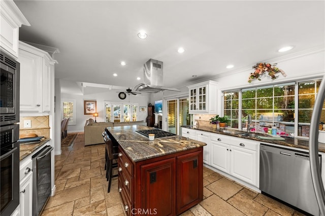 kitchen featuring appliances with stainless steel finishes, a center island, white cabinets, a kitchen bar, and decorative backsplash