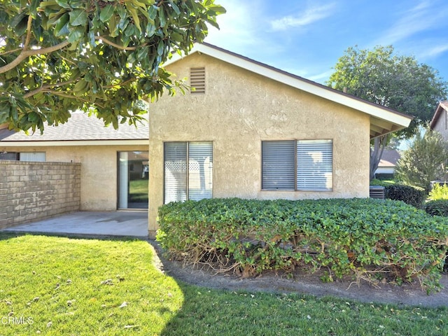 back of house with a yard and a patio