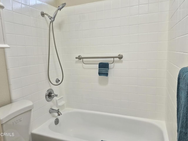 bathroom featuring tiled shower / bath and toilet