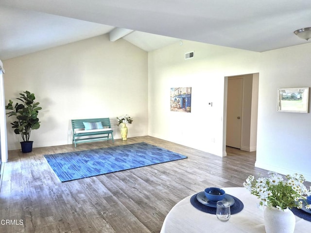 exercise room with vaulted ceiling and hardwood / wood-style floors