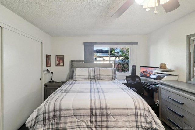 bedroom with a textured ceiling and ceiling fan