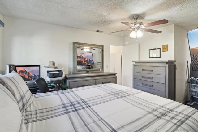 bedroom with ceiling fan and a textured ceiling