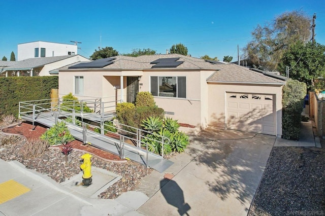 ranch-style home with a garage and solar panels