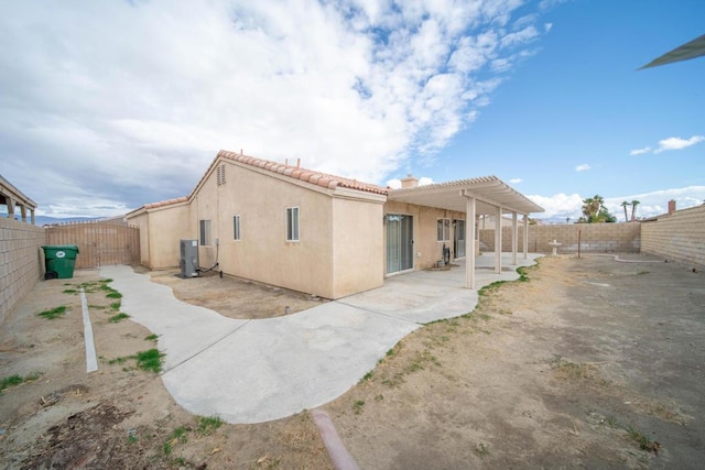 rear view of house featuring a pergola and a patio area