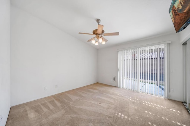 carpeted spare room with vaulted ceiling and ceiling fan