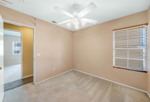 carpeted spare room featuring ceiling fan