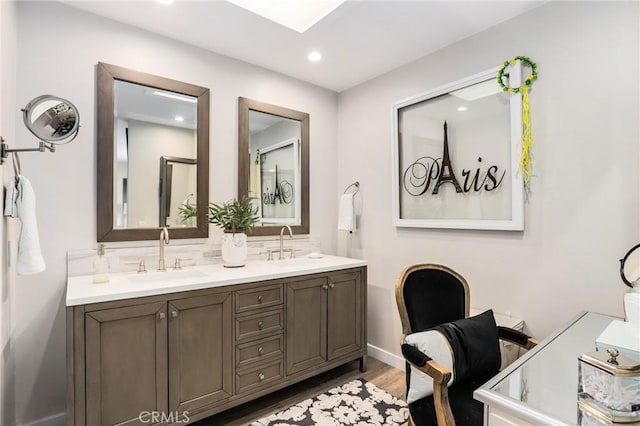 bathroom featuring vanity, hardwood / wood-style floors, and backsplash