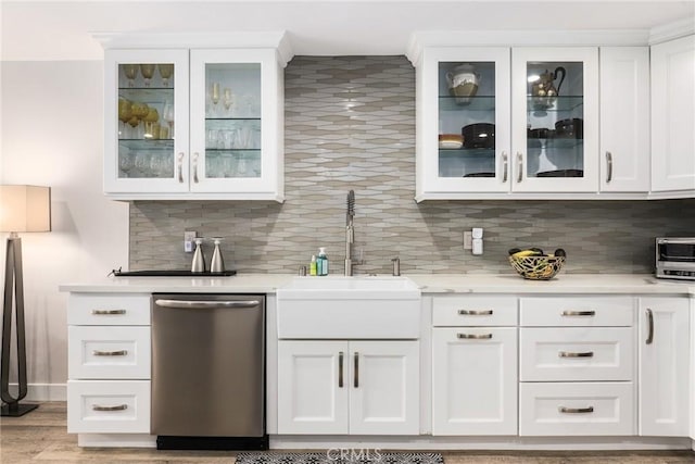 bar with sink, light hardwood / wood-style flooring, white cabinetry, decorative backsplash, and stainless steel dishwasher