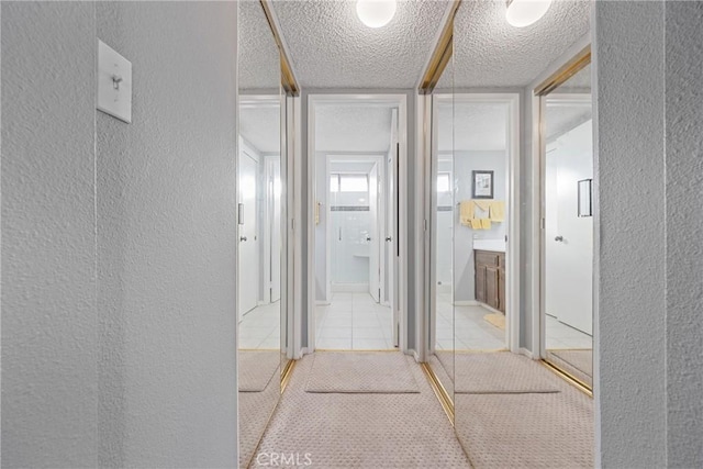 hallway with tile patterned flooring and a textured ceiling