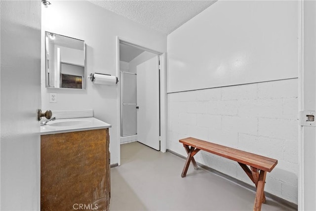 bathroom with vanity, concrete floors, and a textured ceiling