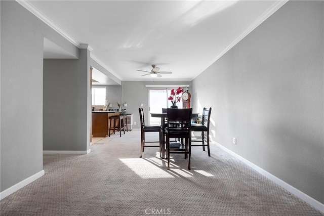 dining space featuring crown molding, light colored carpet, and ceiling fan