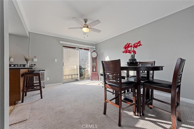 dining space featuring light carpet, ornamental molding, and ceiling fan