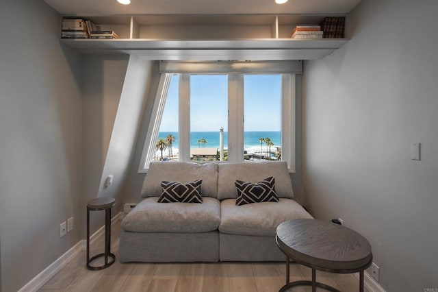 living room with a water view and light hardwood / wood-style flooring