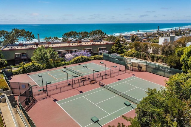 view of tennis court featuring a water view