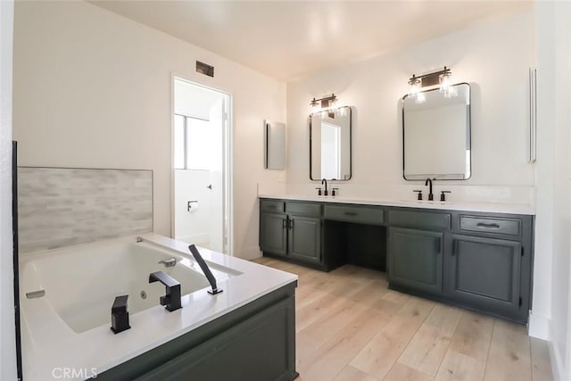20591 Celtic St, Chatsworth, CA 91311 - full bathroom featuring a jetted tub, visible vents, wood finished floors, and a sink