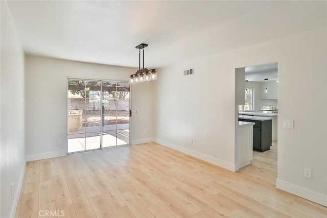 20591 Celtic St, Chatsworth, CA 91311 - unfurnished dining area with visible vents, light wood-style flooring, and baseboards