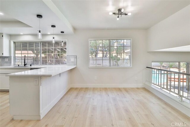 20591 Celtic St, Chatsworth, CA 91311 - kitchen with baseboards, white cabinets, plenty of natural light, and a sink