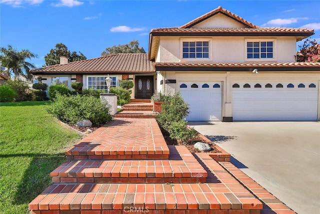 mediterranean / spanish home with a garage and a front yard