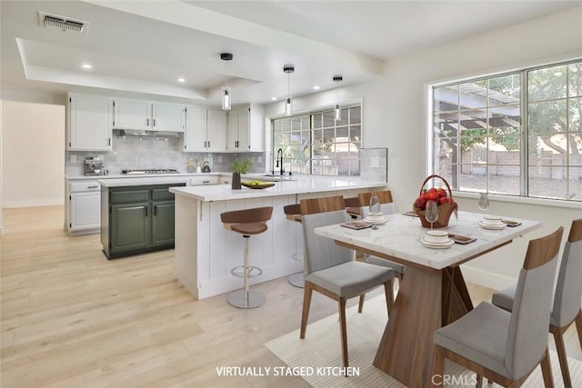 20591 Celtic St, Chatsworth, CA 91311 - kitchen with recessed lighting, cooktop, light wood-style floors, visible vents, and a tray ceiling
