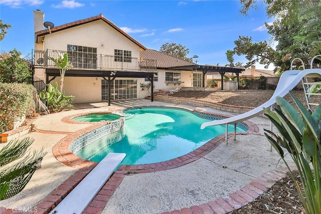 20591 Celtic St, Chatsworth, CA 91311 - view of swimming pool with a pool with connected hot tub, a patio area, a diving board, a fenced backyard, and a water slide
