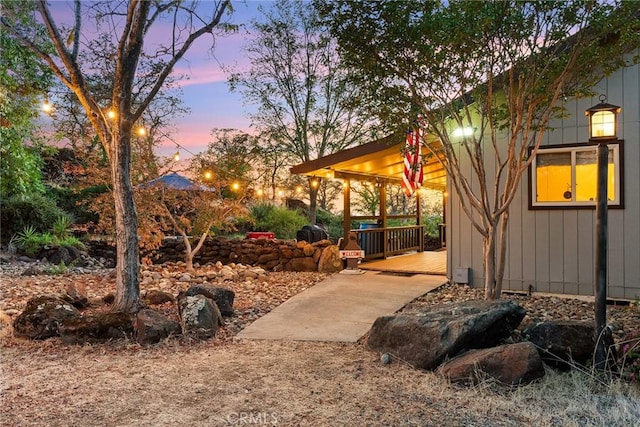 yard at dusk featuring a deck