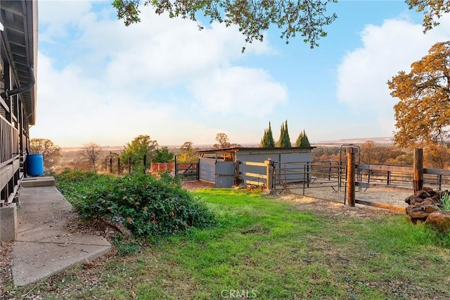 yard at dusk featuring an outdoor structure and a rural view