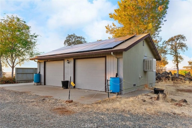 garage featuring a wall mounted air conditioner and solar panels