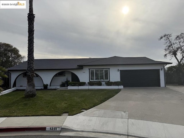 single story home with a garage and a front lawn