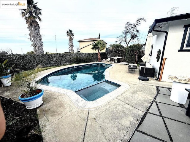 view of pool featuring an in ground hot tub and a patio area