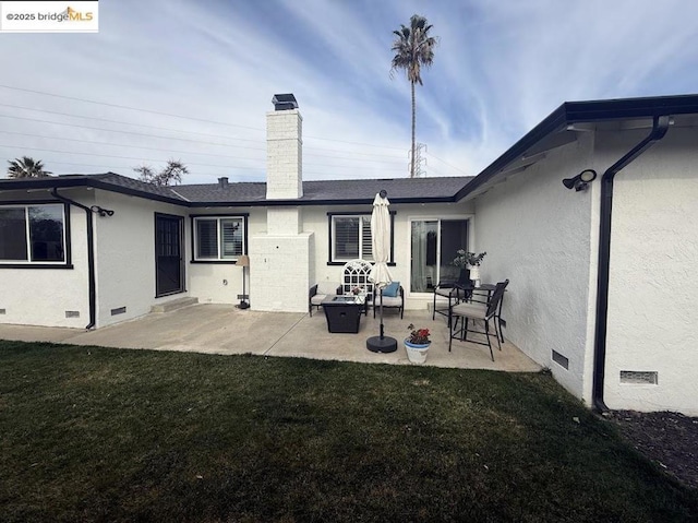 rear view of property featuring a yard and a patio area