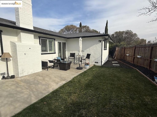 rear view of property with a patio, outdoor lounge area, and a yard